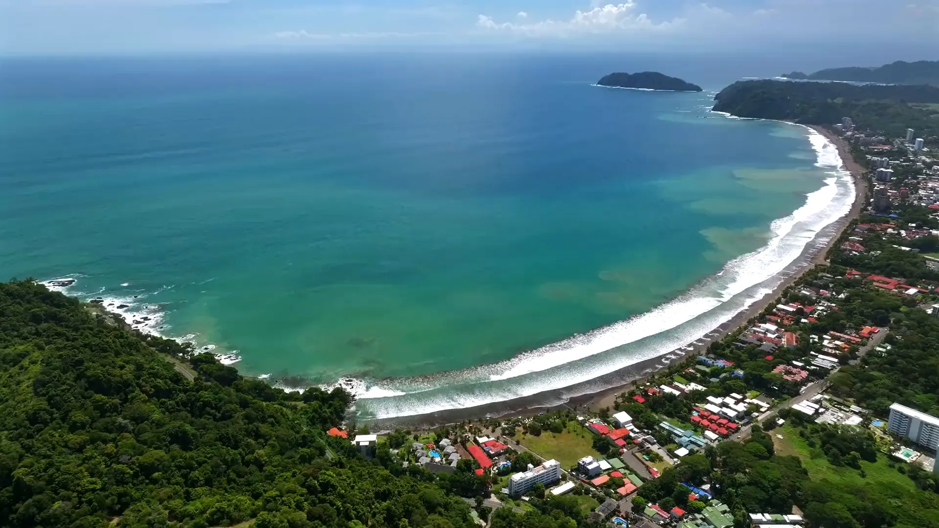 Aerial view of the bay at Jacó, the opening frame of the Sueños del Mar background film