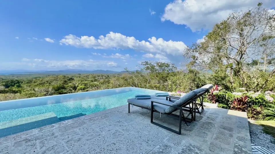 Infinity pool with a panoramic valley and ocean view